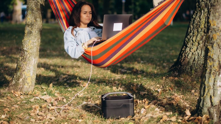 a digital nomad woman working remotely from her hammock as part of her RV office setup